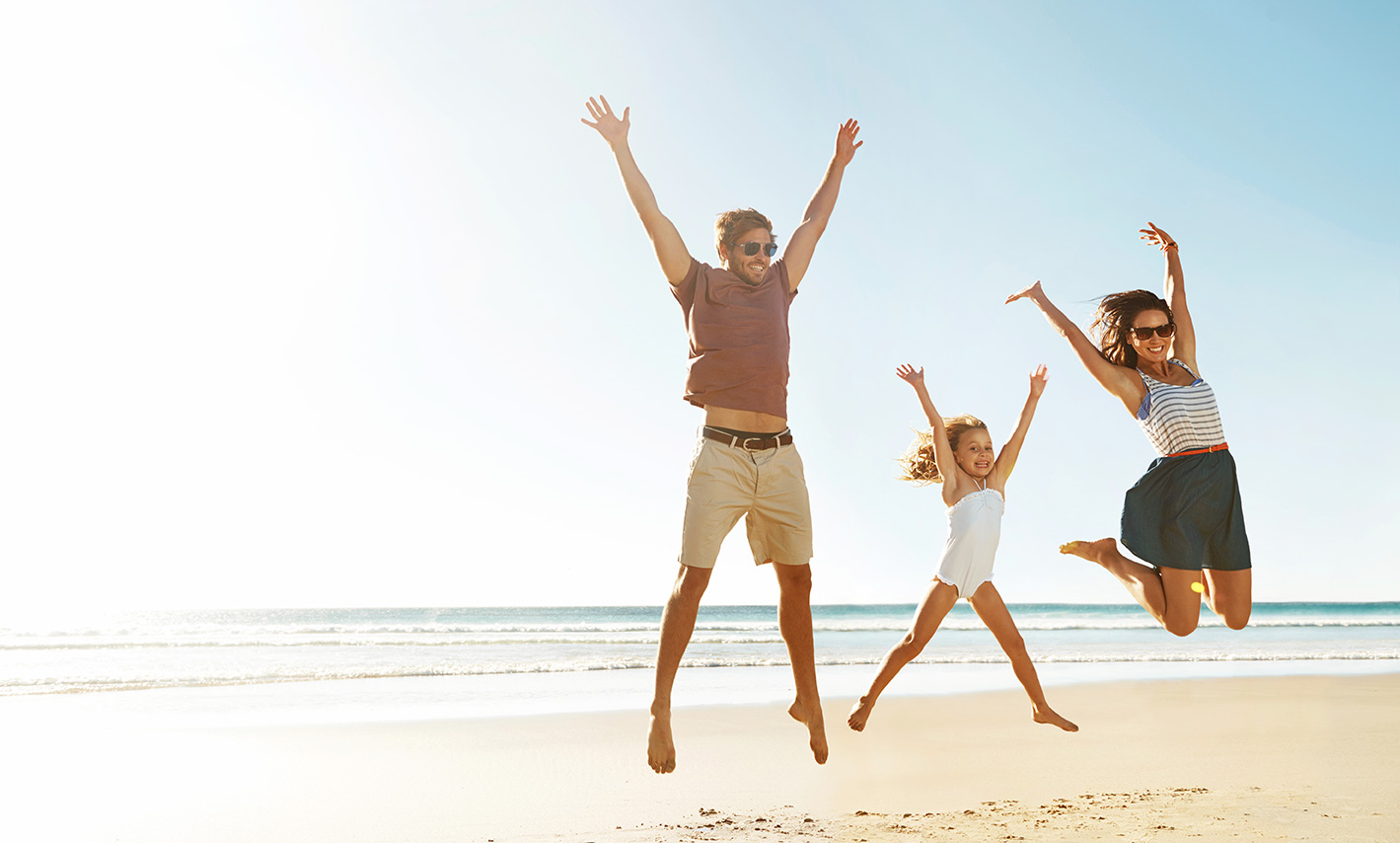 ETI_Mädchen und Eltern Mädchen mit seinen Eltern beim Springen am Strand