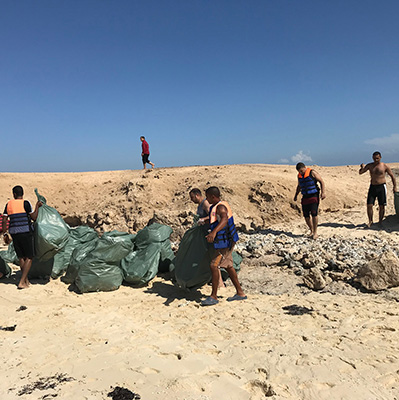 Freiwilligen nehmen die befüllten Mülltüten weg