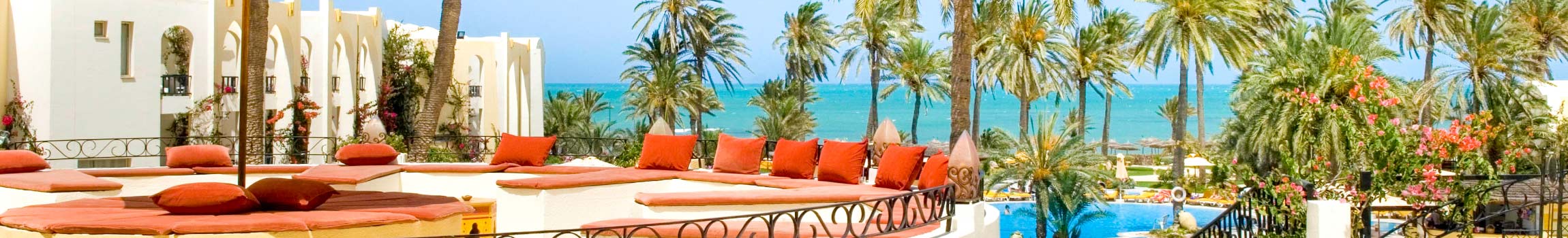 Hotel-Terrasse mit Ausblick auf den daran liegenden feinsandigen Strand