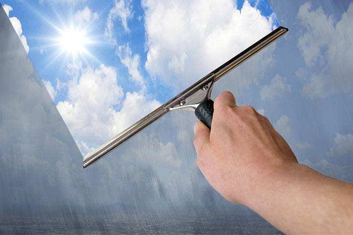 Hand mit Scheibenwischer, der die Scheibe säubert