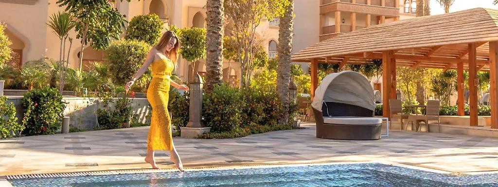 Frau in gelbem Kleid am Pool im Adults Only Hotel