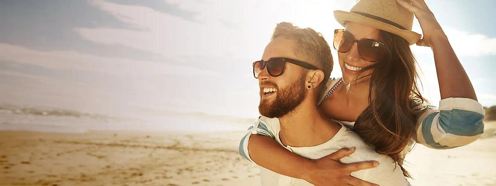 Frau umarmt Mann am Strand von Ägypten im Aktivurlaub