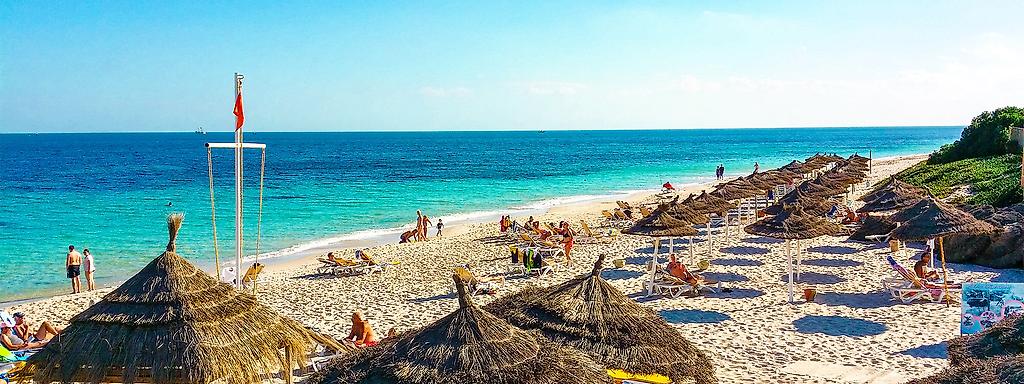 Strand von Sousse. Sonnenschirme und Urlauber mit Blick aufs Meer.