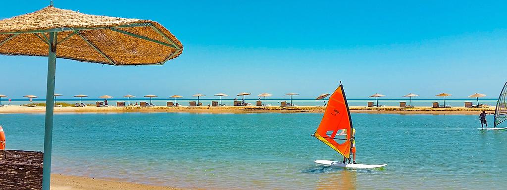 Surfer auf dem Meer in El Gouna mit Sonnenschirmen