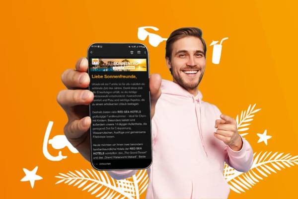 Mann hält Handy in der Hand mit ETI Newsletter auf dem Bildschirm