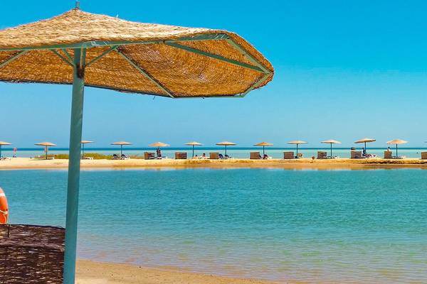 Surfer auf dem Meer in El Gouna mit Sonnenschirmen